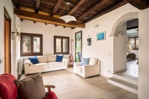 a living room with two white couches and blue pillows at Case Peschiera 17 in Nuragheddu