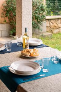 a table with plates of food and a bottle of wine at Case Peschiera 17 in Nuragheddu