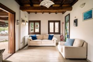 a living room with two white couches and blue pillows at Case Peschiera 17 in Nuragheddu +24 photos