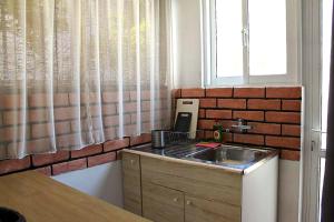 a kitchen with a sink and a brick wall at Nice house close to the sea in Mati