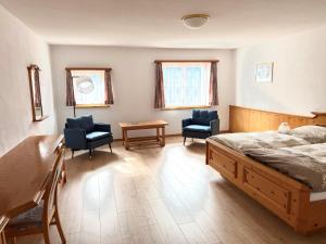 a bedroom with a bed and two chairs and a table at Hotel La Soglina in Soglio