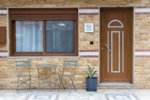 a building with a door and two chairs and a table at Thalori Home Georgioupolis in Georgioupolis
