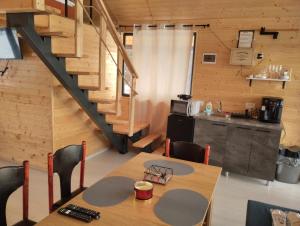 a dining room with a table and a staircase at Cabana Valea Brazilor in Tutana