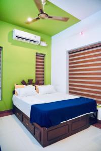 a bedroom with a large bed with a ceiling fan at J V A Home stay Apartment Hotel in Kollam +53 photos