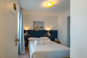 a bedroom with a white bed with two pillows at Il Platano Guest House in Quartino