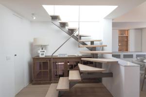 a staircase in a living room with a table and a desk at Villa Oro in Oia