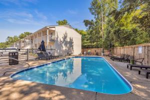 a swimming pool with benches and a house at The Porter Chamber in Ocean Springs