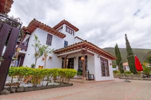 a white house with a red umbrella at Condominio The monkey House in Villa de Leyva