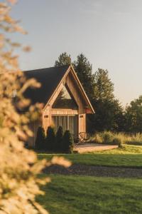 ein großes Holzhaus mitten auf einem Feld in der Unterkunft Osada Augustów in Mirsk + 34 Fotos