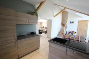 a kitchen with wooden cabinets and a sink at Chez soule in Riupeyrous