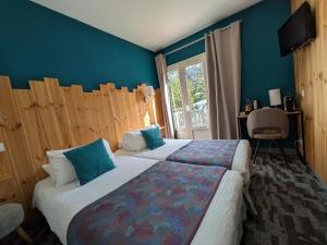 a hotel room with two beds with blue walls at Logis Hotel Eden Lac in Savines