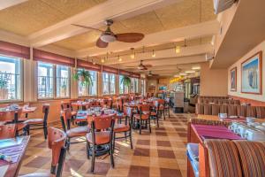 a restaurant with tables and chairs and windows at Reges Oceanfront Resort in Wildwood Crest