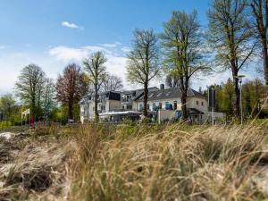 a large house on a beach with tall grass at Hof Sierksdorf in Sierksdorf