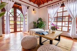 a living room with a table and chairs and windows at Condominio The monkey House in Villa de Leyva