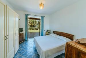 a bedroom with a bed and a sliding glass door at Casa del passero - Villa with Infinity Garden and Sea View in Forio d'Ischia