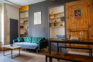 a living room with a blue couch and a table at Le Millésime in Dijon