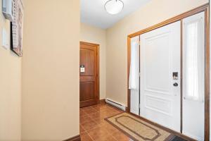 a hallway with a white door and a tile floor at House On The Golf La Bte -10min To Tremblant 150 in Mont-Tremblant