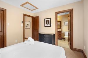 a bedroom with a white bed and a bathroom at House On The Golf La Bte -10min To Tremblant 150 in Mont-Tremblant +34 photos