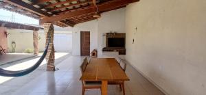 a large room with a wooden table and a hammock at Casa Parnaíba in Parnaíba