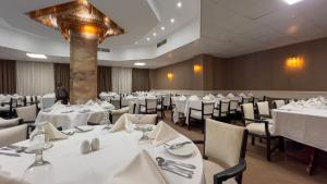 a dining room with white tables and chairs at Sahary Pyramids View Hotel in Giza
