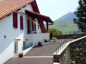 a white building with red windows and a fence at Aguerrea in Macaye +18 photos