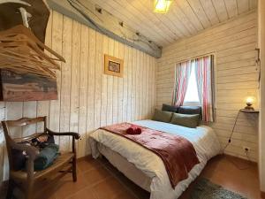 ein Schlafzimmer mit einem Bett, einem Stuhl und einem Fenster in der Unterkunft Garate in Espelette