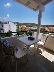 a white table and chairs on a balcony at Hotel ADMIRAL POTOS THASSOS in Potos