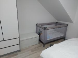 a small bedroom with a crib and a bed at Apartman Kovačić in Kutina