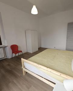 a bedroom with two beds and a red chair at b apartments in Case Bruciate