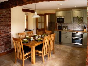 a kitchen with a wooden dining table and chairs at Tyn Y Celyn Canol in Clocaenog