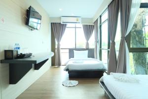 a hotel room with two beds and a window at A Plus Deluxe Hotel in Ko Lipe