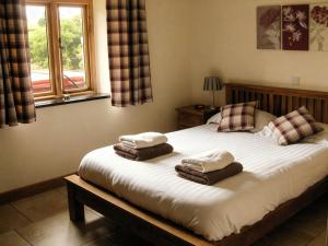 a bedroom with a large bed with towels on it at Tyn Y Celyn Canol in Clocaenog