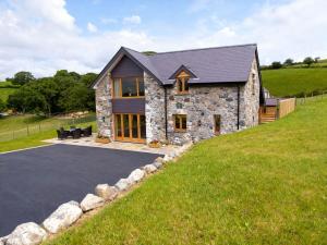a stone house on a hill with a driveway at Tyn Y Celyn Canol in Clocaenog