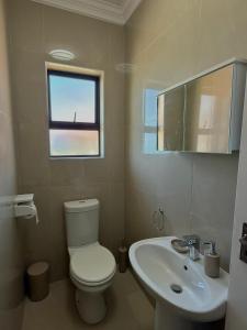 a bathroom with a toilet and a sink and a window at Oceanview Oasis in Freeland Park +17 photos