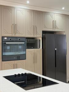 a kitchen with a black refrigerator and white cabinets at Oceanview Oasis in Freeland Park