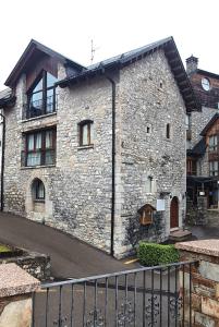a stone building with a black fence in front of it at HOTEL EL Alboroque in Tramacastilla de Tena