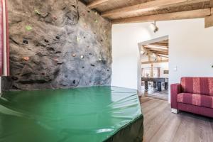 a rock climbing wall in a room with a couch at Ferienhof Oberreit in Bruck an der Großglocknerstraße