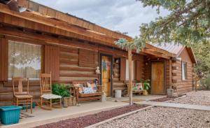 a log cabin with a porch and a bench and chairs at Milner Pass Cabin Retreat in South Fork