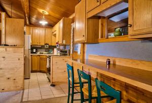 a kitchen with wooden cabinets and green chairs at Milner Pass Cabin Retreat in South Fork +10 photos
