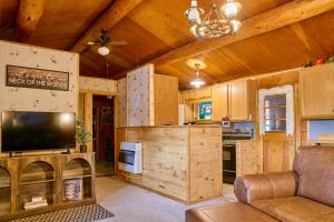 a living room with a tv and a couch and a kitchen at Milner Pass Cabin Retreat in South Fork