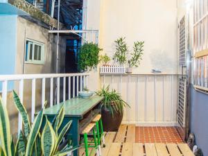 a balcony with a table and potted plants at Tainan Gu Hostel in Tainan