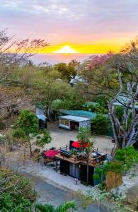 an aerial view of a house with the sunset in the background at Pura Vida Rent in Nosara