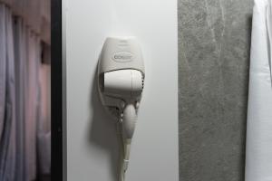 a hair dryer is hanging on a wall at Pura Vida Rent in Nosara