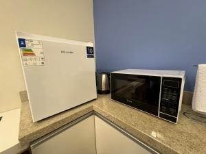 a microwave oven sitting on top of a kitchen counter at Suite Juede Platz - 02 - Centro de Pomerode in Pomerode