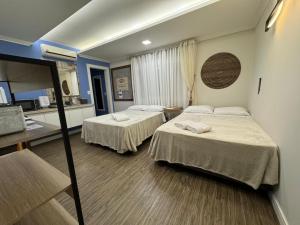 a hotel room with two beds and a kitchen at Suite Juede Platz - 02 - Centro de Pomerode in Pomerode