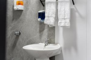 a bathroom with a white sink and towels at Pura Vida Rent in Nosara +19 photos