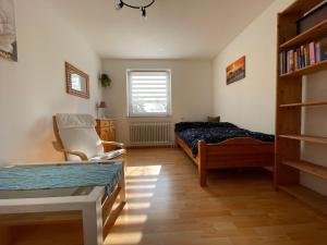 a bedroom with a bed and a chair and a book shelf at Urlaubsort Fränkisches Seenland in Haundorf