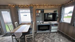 a living room with a table and a tv and a dining room at East Lothian Escape in Port Seton
