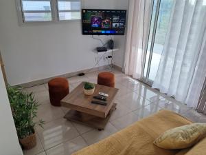 a living room with a table and chairs and a tv at Villas Sarique in Grand-Bourg