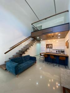 a living room with a blue couch and a staircase at Bello Departamento in Mexicali
